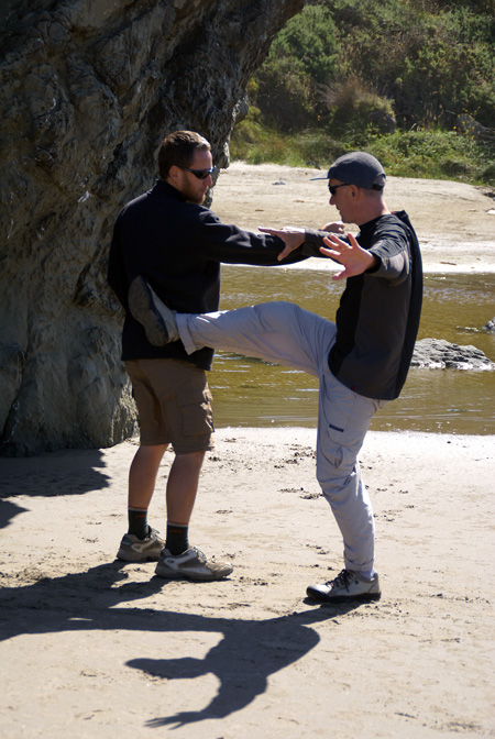Gene Burnett and Neil Buettner doing tai chi applications on the beach at Bandon -- kicking.